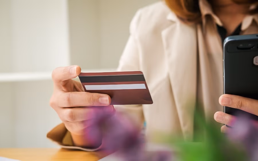 Persona con una tarjeta bancaria y el móvil