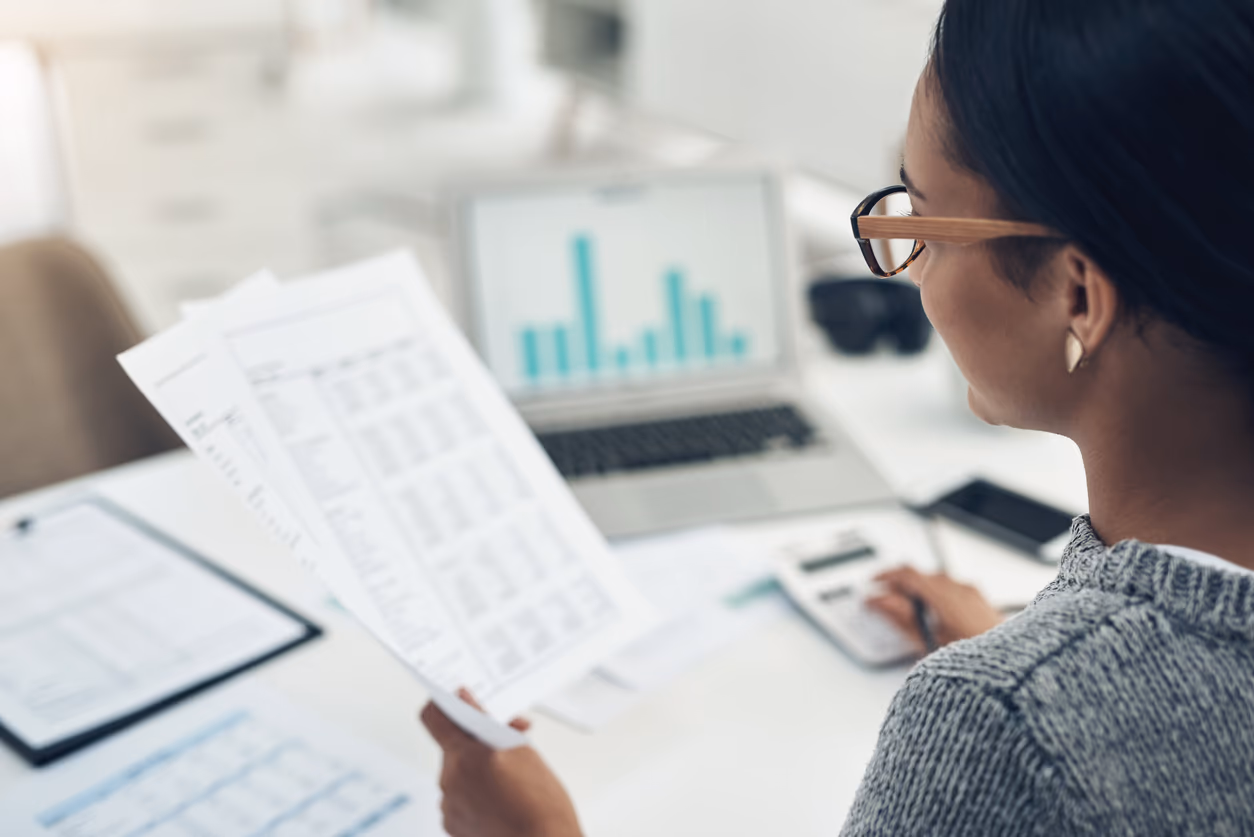 Persona revisando sus extractos y documentos financieros
